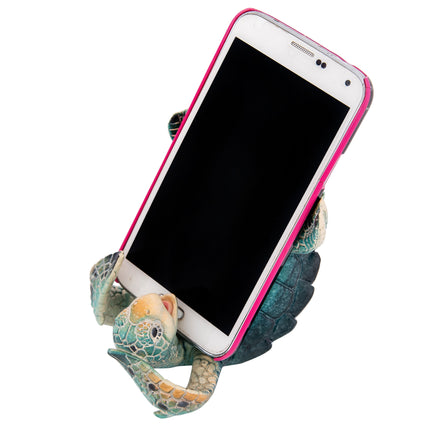 Phone holder shaped like a turtle with a smartphone on a white background