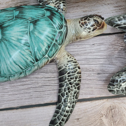 Three aqua blue metal sea turtles swimming in a family group, detailed coastal wall sculpture for beach-themed home decor.