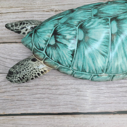 Three aqua blue metal sea turtles swimming in a family group, detailed coastal wall sculpture for beach-themed home decor.
