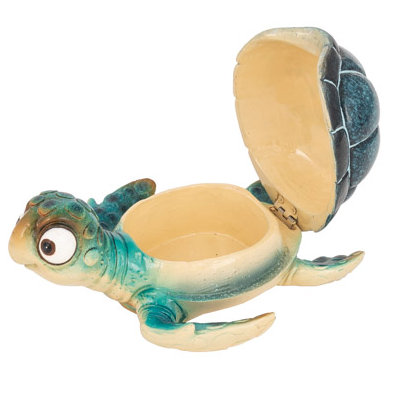 Whimsical blue cartoon turtle figurine with large bug eyes and a functional hinged shell for storing jewelry or trinkets; shown as both coastal wall art and a tabletop decorative box.